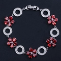 Elegante bracciale in argento con fiori di gemme rosse e anelli di zirconi su fondo nero - Rosso