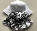 Reversible coconut tree print bucket hat for men and women shown in white and floral patterns - White