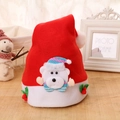 Detail of red Christmas hat featuring a plush white bear ornament and red berry accents - Bear Style