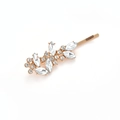 Vue détaillée de la barrette dorée avec motif de feuilles et strass transparents - Doré