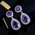Macro view of pear-shaped purple zircon earrings with halo settings and silver finish - Purple