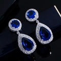 Vista macro di orecchini pendenti in argento con zaffiri blu e micro zirconi incastonati - Blu
