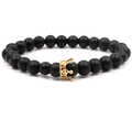 Détail de perles en pierre noire mate avec un pendentif couronne doré serti de zircons - Pierre Noire Couronne Dorée