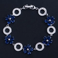 Detaillierte Makroansicht von Silber-Blumenarmband mit blauen Zirkonia auf schwarzem Grund - Blau