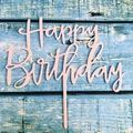 Elegant pink Happy Birthday acrylic cake topper placed on a blue textured wood background - Pink