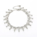 Close-up of silver anklet featuring clear rhinestone tassels and small bell pendant - Circular Ring Rhinestone Style (3660) / Silver