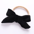 Detail of soft black velvet bow with a beige elastic nylon headband for babies - Black