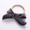 Detailed flat lay of a grey velvet bow on a seamless nylon headband for infants - Gray