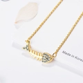 Golden fishbone pendant necklace with white crystals and black stone accents - Gold