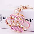 Portachiavi a corona rosa e oro con strass scintillanti su superficie bianca - Rosa