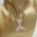 Detail of pink glitter mermaid tail pendant with silver chain on a golden bust - Pink