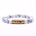 White marble bead bracelet featuring a gold hollow metal tube with black gemstones - White Howlite Cross Beaded Bracelet