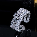 Macro shot of silver open ring with pave square cubic zirconia on black mirror background - Platinum