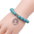 Detail of 10mm turquoise beaded bracelet featuring a tree of life metal charm and spacer - Hollow Tree of Life / Silver