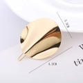Detailed view of a 4.2cm golden wave-patterned circular metal hair clip on white card - Gold - Wavy Disc