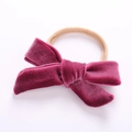 Detail view of a berry velvet bow headband on a beige soft nylon elastic strap - Rose Red
