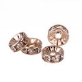 Macro shot of rose gold spacer beads with clear rhinestones for DIY jewelry making - 6mm / Rose Gold + White Rhinestone