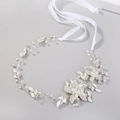 Vista macro dell'accessorio sposa fatto a mano con perle bianche e cristalli lucidi - Argento