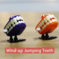 Wind-up jumping vampire teeth toy in orange and purple for Halloween gift and fun - Fangs