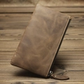 Macro shot of brown crazy horse leather wallet with zipper detail on a rustic wooden table - Crazy Horse Khaki
