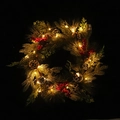 Christmas wreath with pine needles, cones, red berries and warm LED lights on black background - With Warm LED Lights