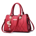 Borsa a mano in pelle rossa con trama a rombi e ciondolo con nappa e perla dorata - Borgogna