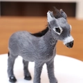 Lifelike grey simulated reindeer figure with black mane on a white display stand - Grey Donkey / Gray