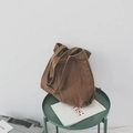 Minimalist oversized brown canvas tote bag displayed on a green side table - Khaki
