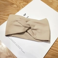 Detailed close-up of khaki ribbed knit headband with cross knot and soft elastic texture - Beige