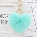 Close-up of a heart-shaped faux fur keychain in mint green with a gold metal clasp - Mint Green