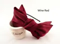 Detail of burgundy satin double-layered oversized bow headband on a ceramic cup - Burgundy Headband