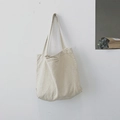 Minimalist cream-white canvas tote bag in cotton linen hanging on a white wall - White