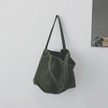 Minimalist military green canvas tote bag with shoulder straps hanging on a white wall - Green