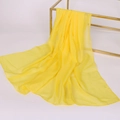 Elegant long yellow chiffon scarf hanging on a metal rack with a soft professional drape - Solid Color / Bright Yellow