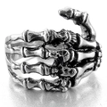 Macro detail of gothic skull hand ring in vintage silver finish with retro punk style - US 7