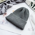 Detailed view of dark grey knitted beanie with soft ribbed texture on magazine backdrop - One Size (High Elasticity) / Dark Gray