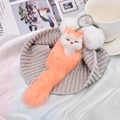 Cute orange plush fox keychain with white faux fur ears on a cozy knit background - Light Peach