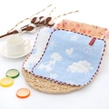 Blue cotton muslin baby towel with giraffe print and red hemmed edges on a straw mat - Blue Animal