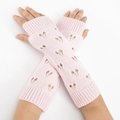 Detail of pink knitted arm warmers with heart cutouts and ribbed cuffs for women - Pink