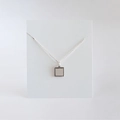 Macro shot of silver S925 square pendant necklace with intricate beaded edge details - Square