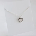 Macro detail of S925 sterling silver heart pendant with beaded edge on display card - Heart