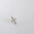 Close-up of a minimalist S925 sterling silver cross pendant necklace on a grey background - Cross