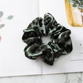 Dettaglio dell'elastico in raso leopardato verde su un elegante marmo bianco - Leopardo Verde Scuro