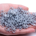 Silver grey beaded bow resin charm for DIY jewelry making shown in hand for size scale - Light Gray