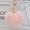 Close-up of fluffy pink heart keychain with golden metal clasp and soft plush texture - Korean Pink