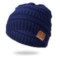 Close-up of dark blue knit beanie showing thick cable pattern and C.C brand leather tag - Navy Blue