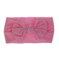 Primo piano di una fascia elastica per neonati in nylon rosa morbido con fiocco - rosa scuro