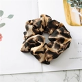 Detailed view of leopard print satin scrunchie on a stylish marble surface background - Leopard Light Brown