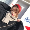 Close-up of a red knitted headband and beige scarf styled with a black sweater - Beige