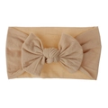 Close-up of a soft peach nylon baby headband with a large decorative bow detail - Nude